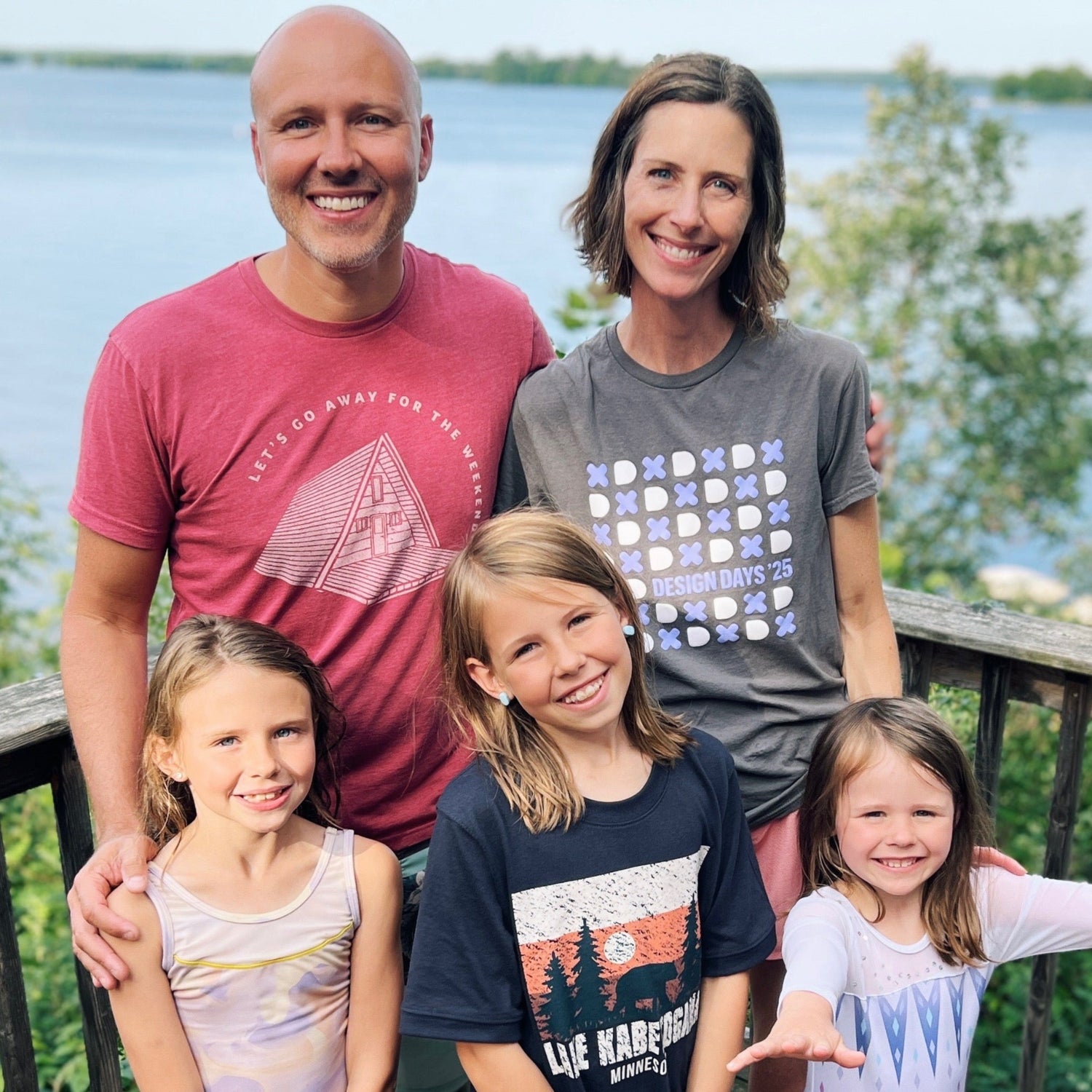 Family of 5 standing on a deck in front of a large lake in Minnesota.